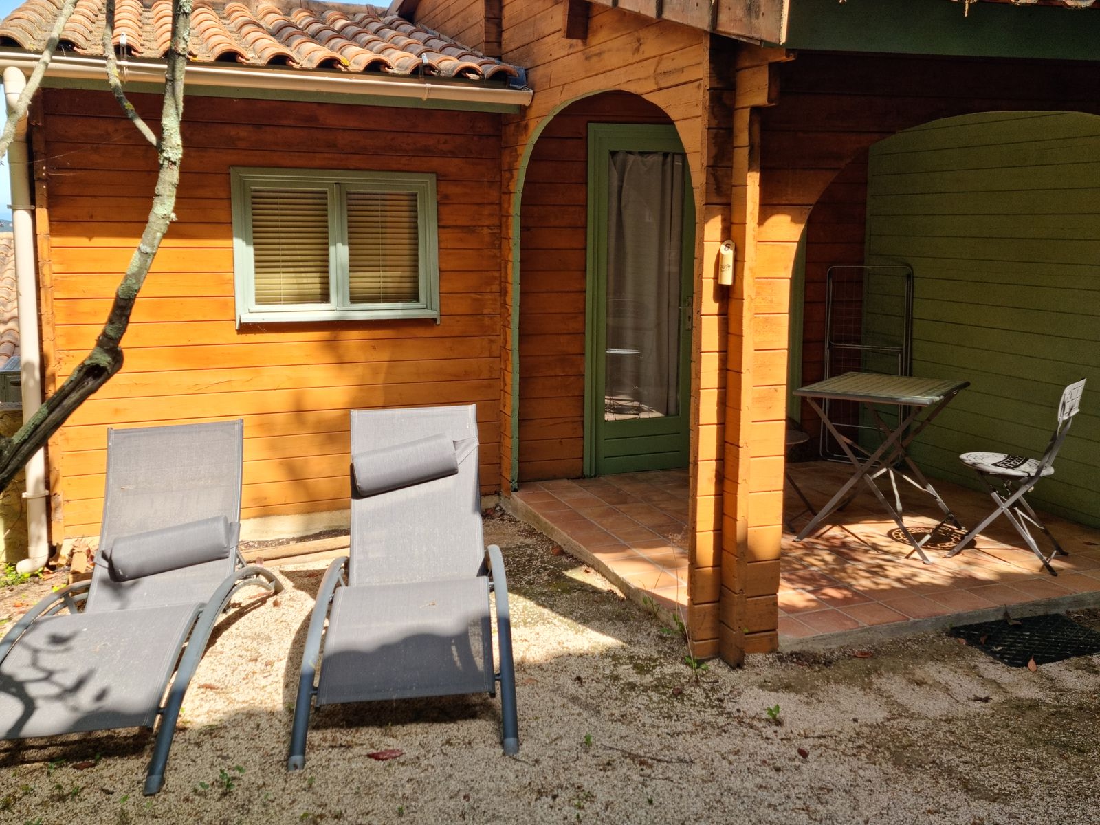 Outdoor space with sun loungers in front of a timber chalet at La Pousterle de Sabran