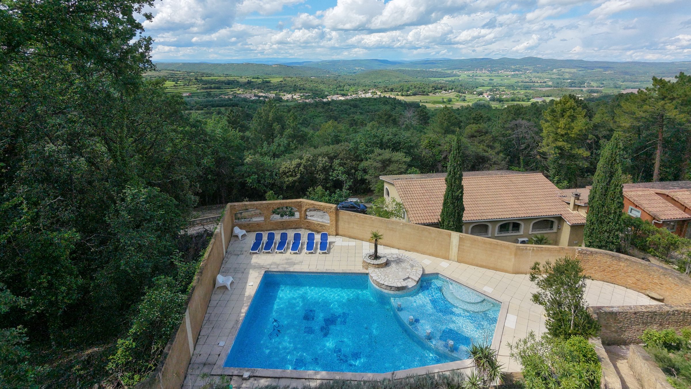The heated pool and terraces of La Pousterle de Sabran looking out over a valley in the Gard, a setting for seminars and private events