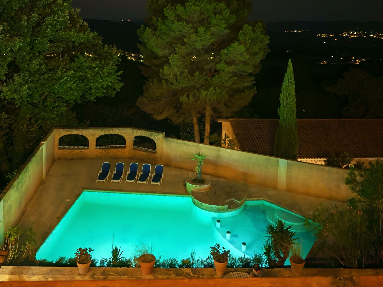 The shared heated pool lit up in the evening, facing the lights of the valley