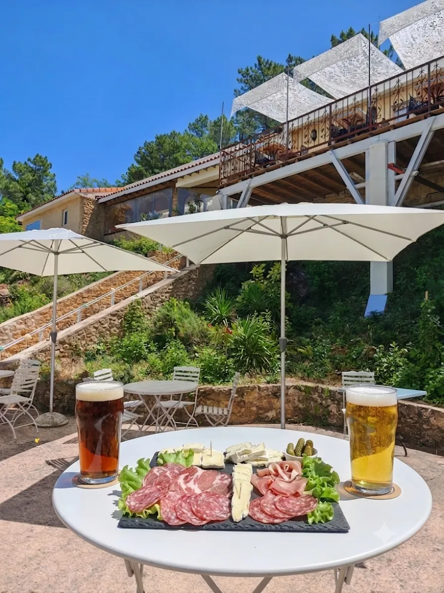 Planche de charcuterie et fromages avec deux bières sur la terrasse du Snack de La Pousterle