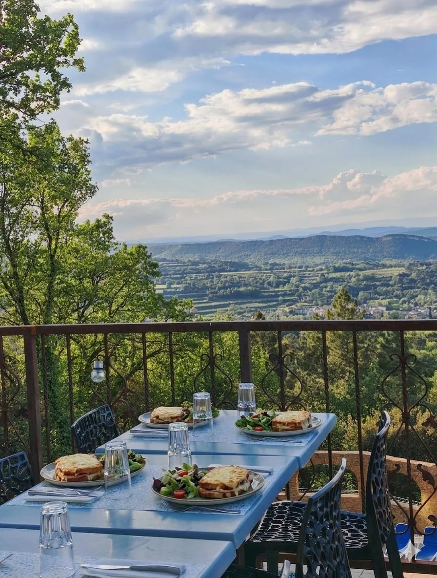 Tables bleues avec croque-monsieurs et salades servis face à la vue panoramique