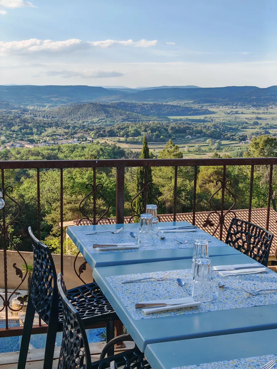 Table bleue dressée sur la terrasse du Snack avec vue panoramique sur la vallée de la Cèze