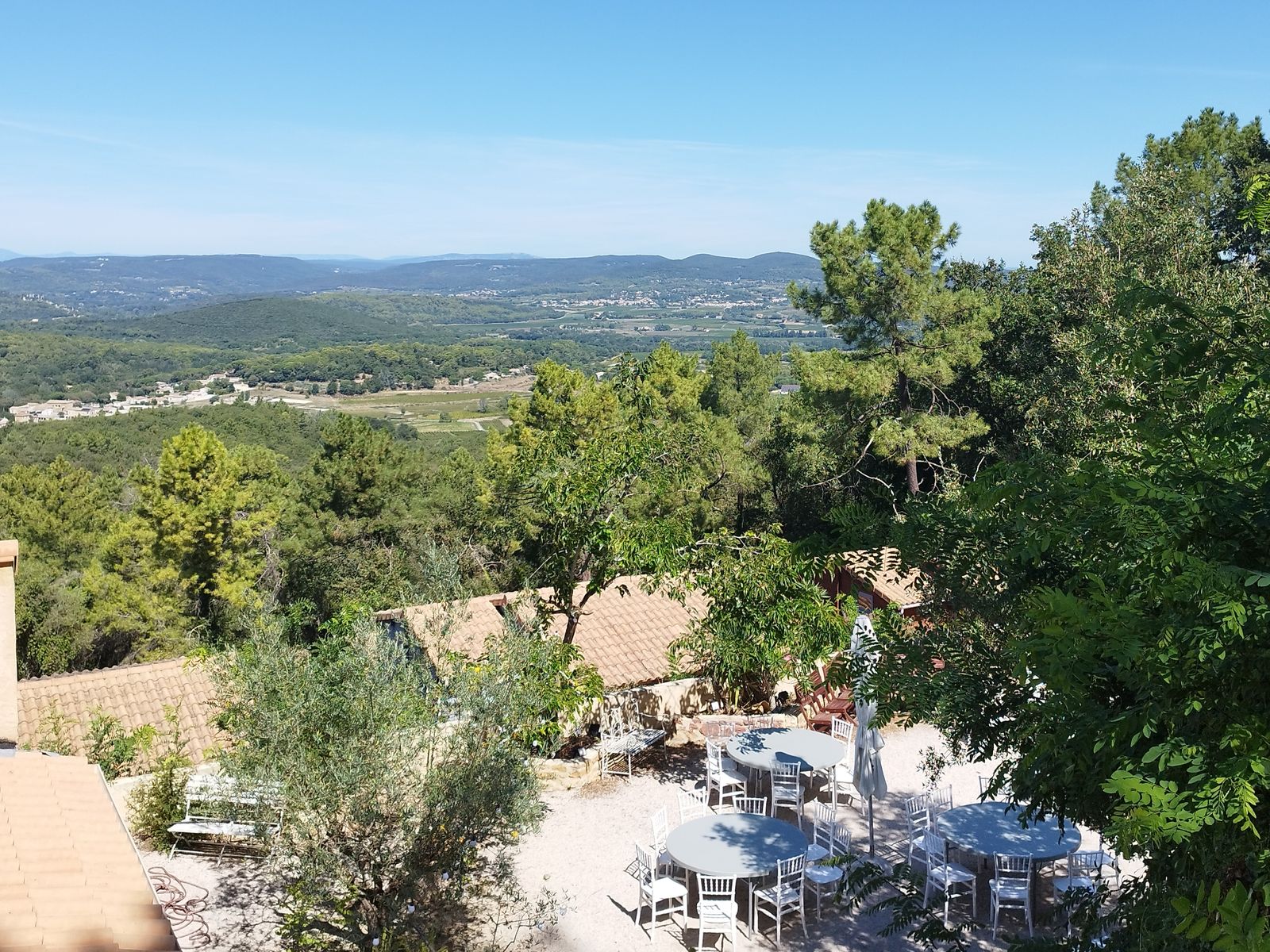 Shaded terrace set for drinks, facing the Cèze valley at La Pousterle de Sabran